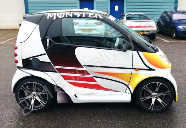 Smart car fully vinyl wrapped in a replica of Lewis Hamiltons 2014 championship winning helmet by Totally Dynamic North London