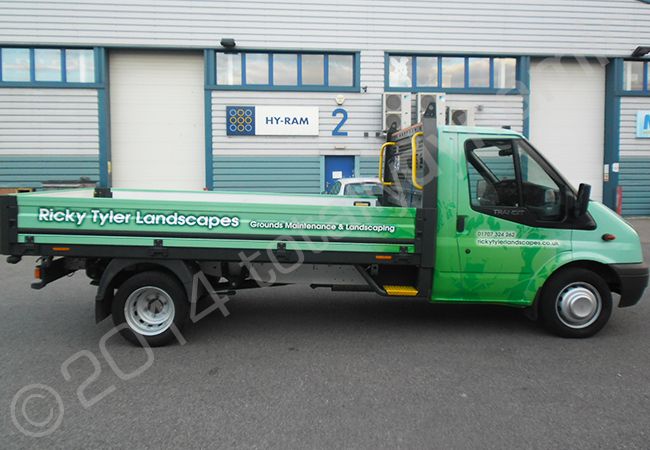 Ford Transit flatbed truck fully vinyl wrapped in a printed vehicle wrap design by Totally Dynamic North London