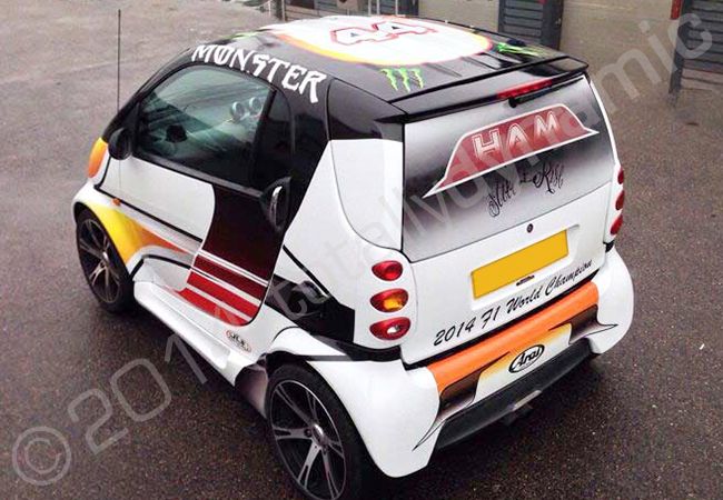 Smart car fully vinyl wrapped in a replica of Lewis Hamiltons 2014 championship winning helmet by Totally Dynamic North London