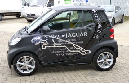 Smart car wrapped in matt black vinyl with chrome vinyl lettering by Totally Dynamic Milton Keynes
